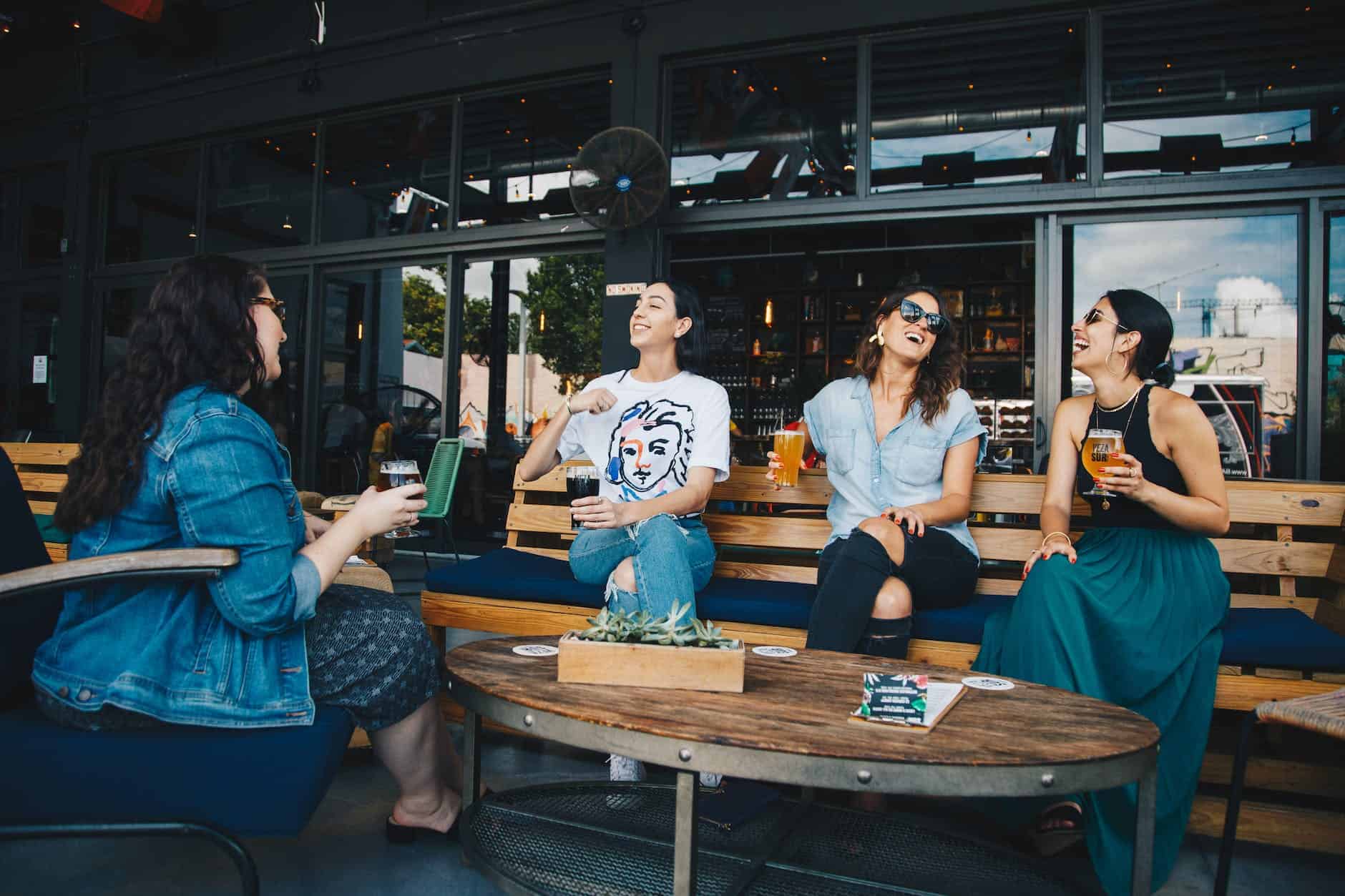 four women chatting while sitting on bench